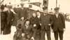 Seven men and two women standing near the rescue ship  S.S. "Sagona." - Sept hommes et deux femmes se tenant près du S.S. "Sagona."